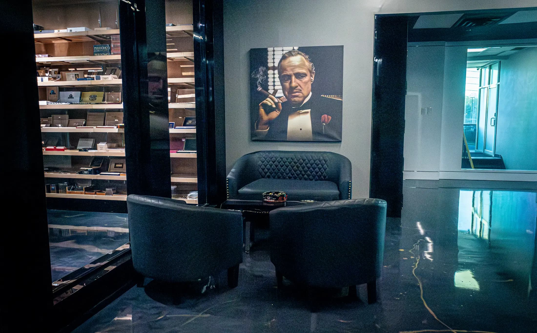 A leather armchair beneath a portrait, beside the humidor